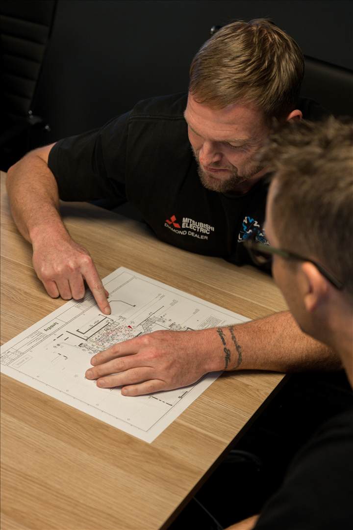 COLDCOAST technicians reviewing a ducted layout plan.